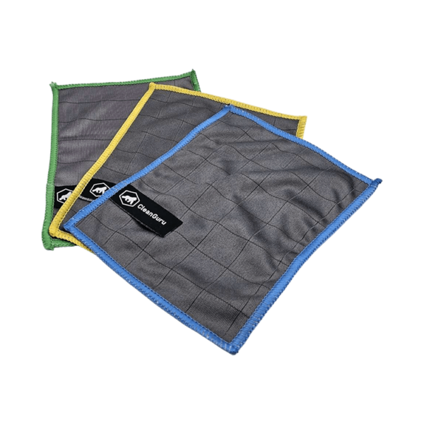 Drei übereinanderliegende Mikrofasertücher in Grau mit unterschiedlich farbigen Rändern in Gelb, Grün und Blau und mit dem „Cleanguru“-Markenlogo auf dem vorderen Tuch, vor grünem Hintergrund.